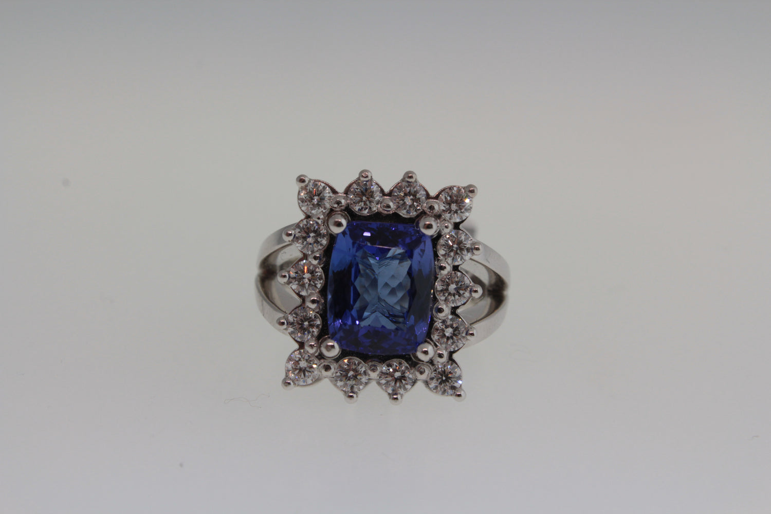 White gold ring with a blue gemstone and diamond accents on a white background