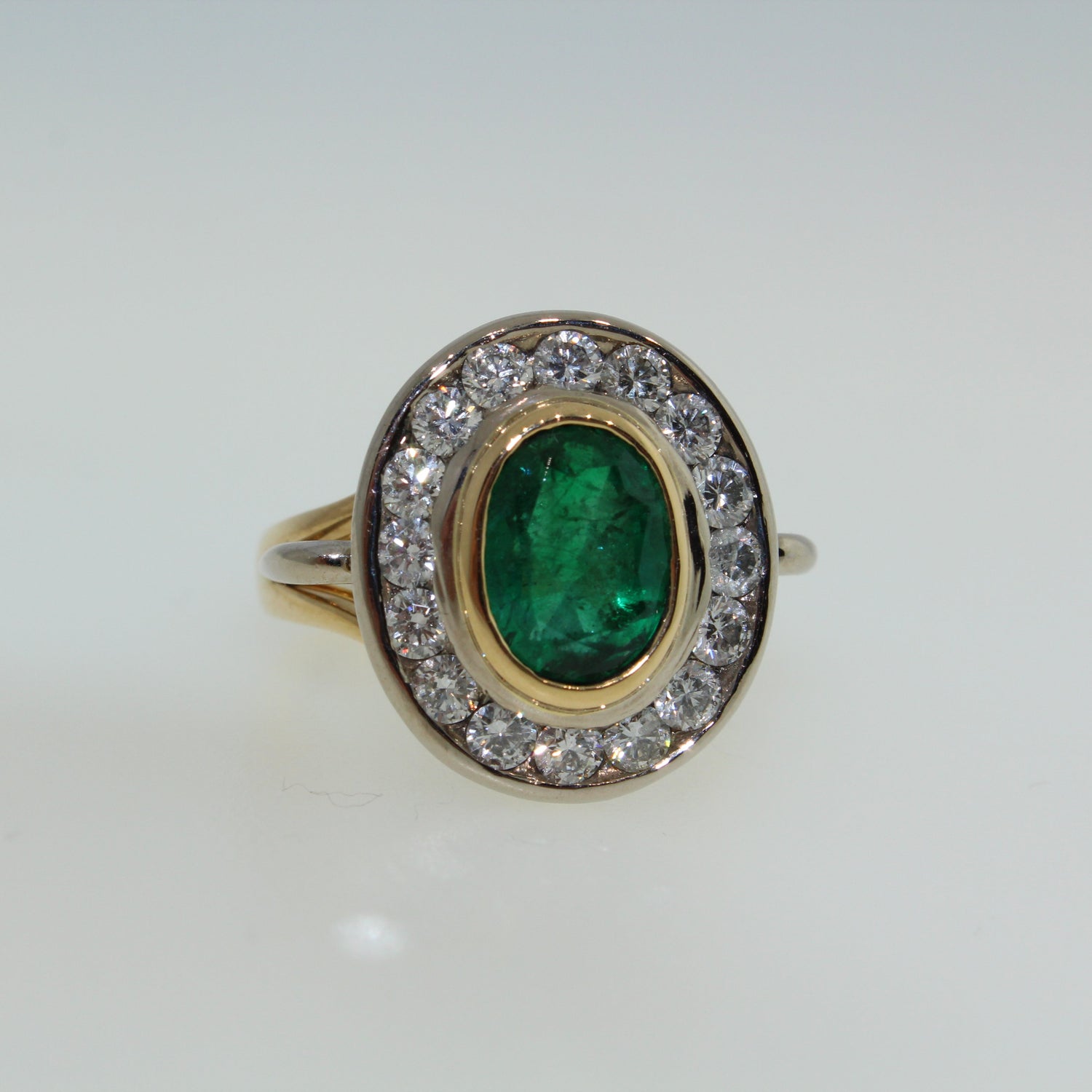 Ring with emerald and diamond accents on a white background