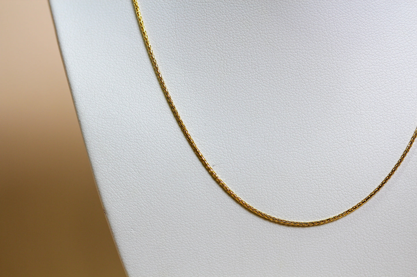 Close-up of solid 9ct yellow gold spiga wheat weave chain showing interlocking angled link construction — Jon Crosbie Jeweller