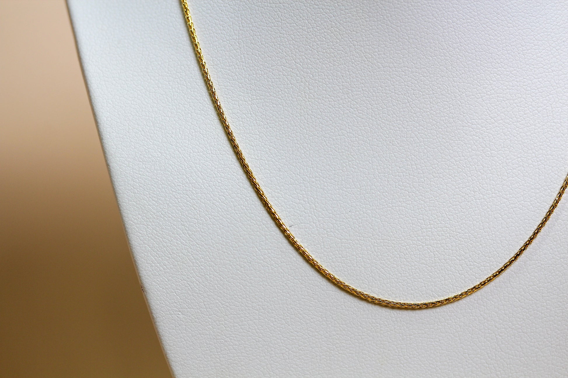 Close-up of solid 9ct yellow gold spiga wheat weave chain showing interlocking angled link construction — Jon Crosbie Jeweller