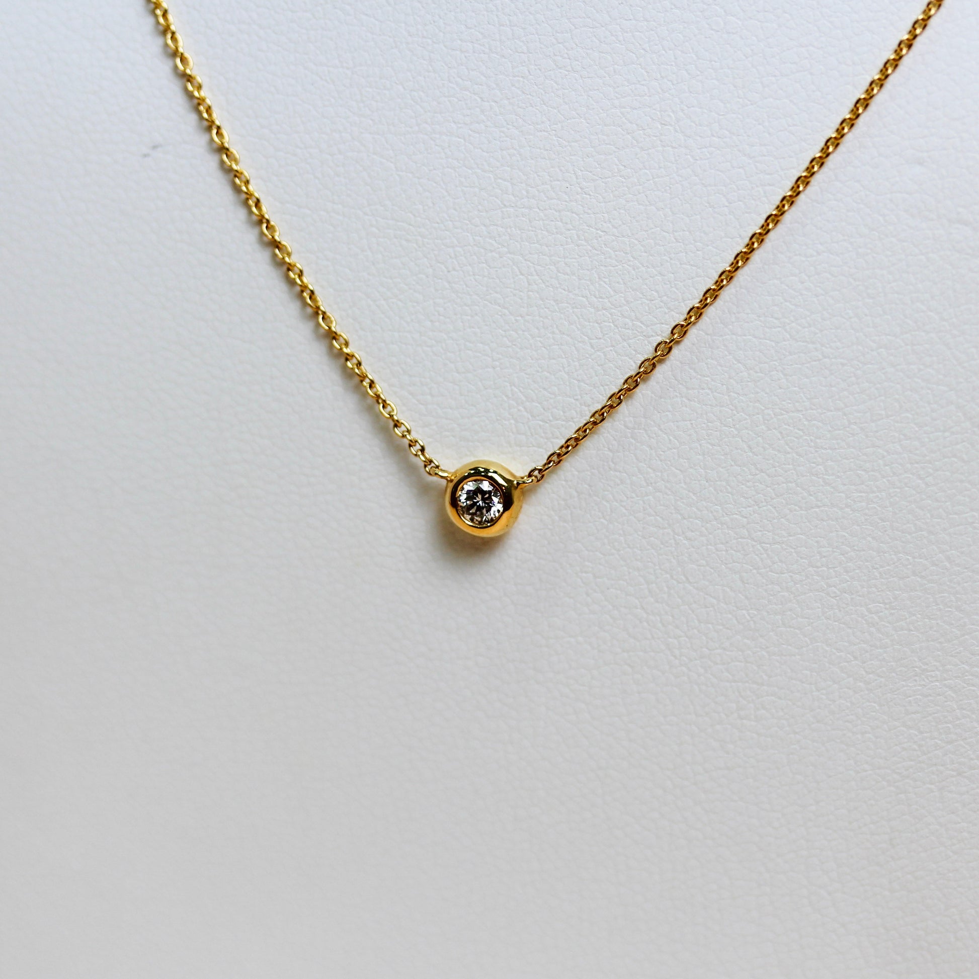 Close-up of natural diamond in smooth 18ct yellow gold full bezel setting — Jon Crosbie Jeweller