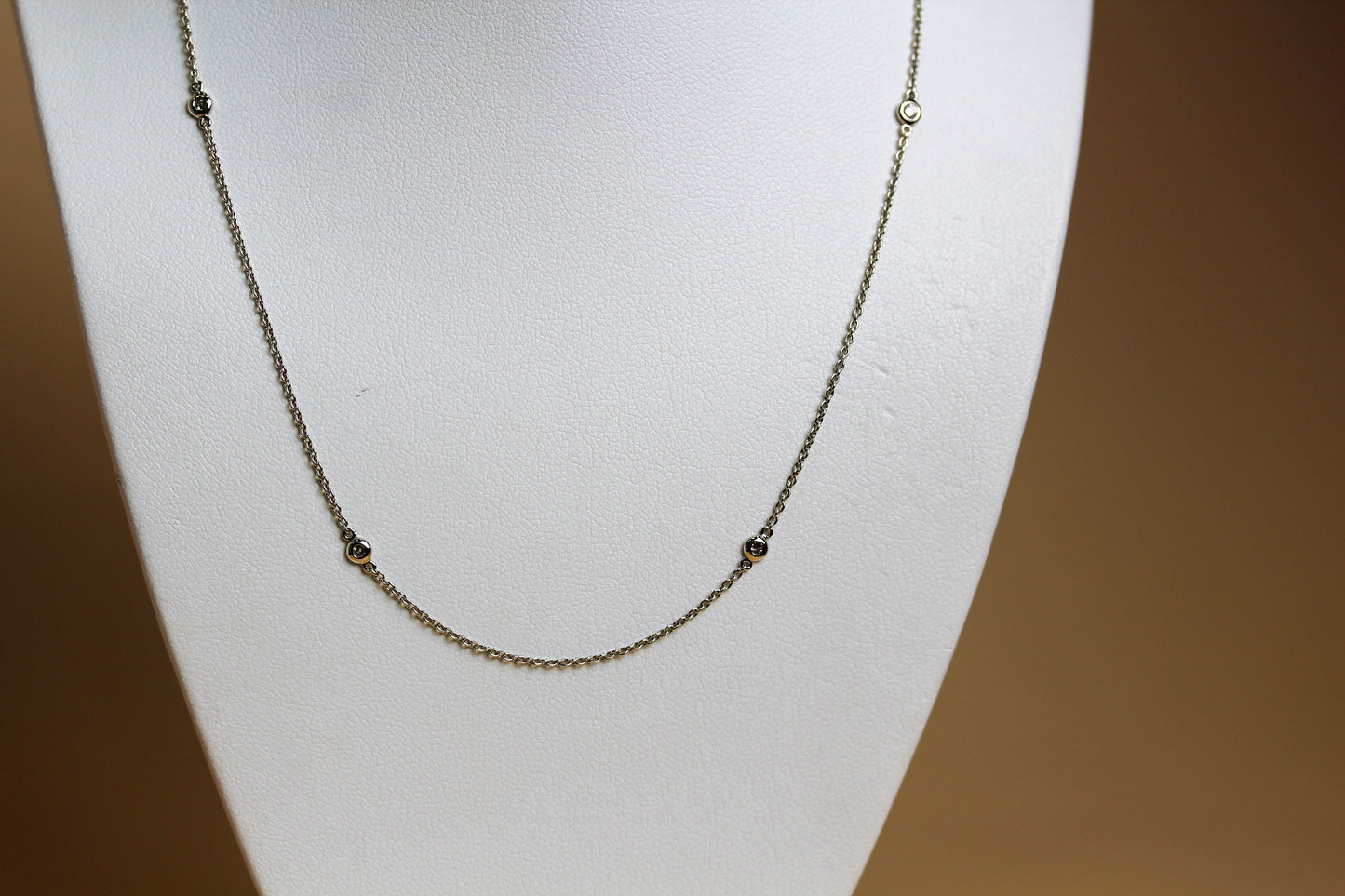 Close-up of natural round brilliant diamond in 18ct white gold bezel station setting — Jon Crosbie Jeweller