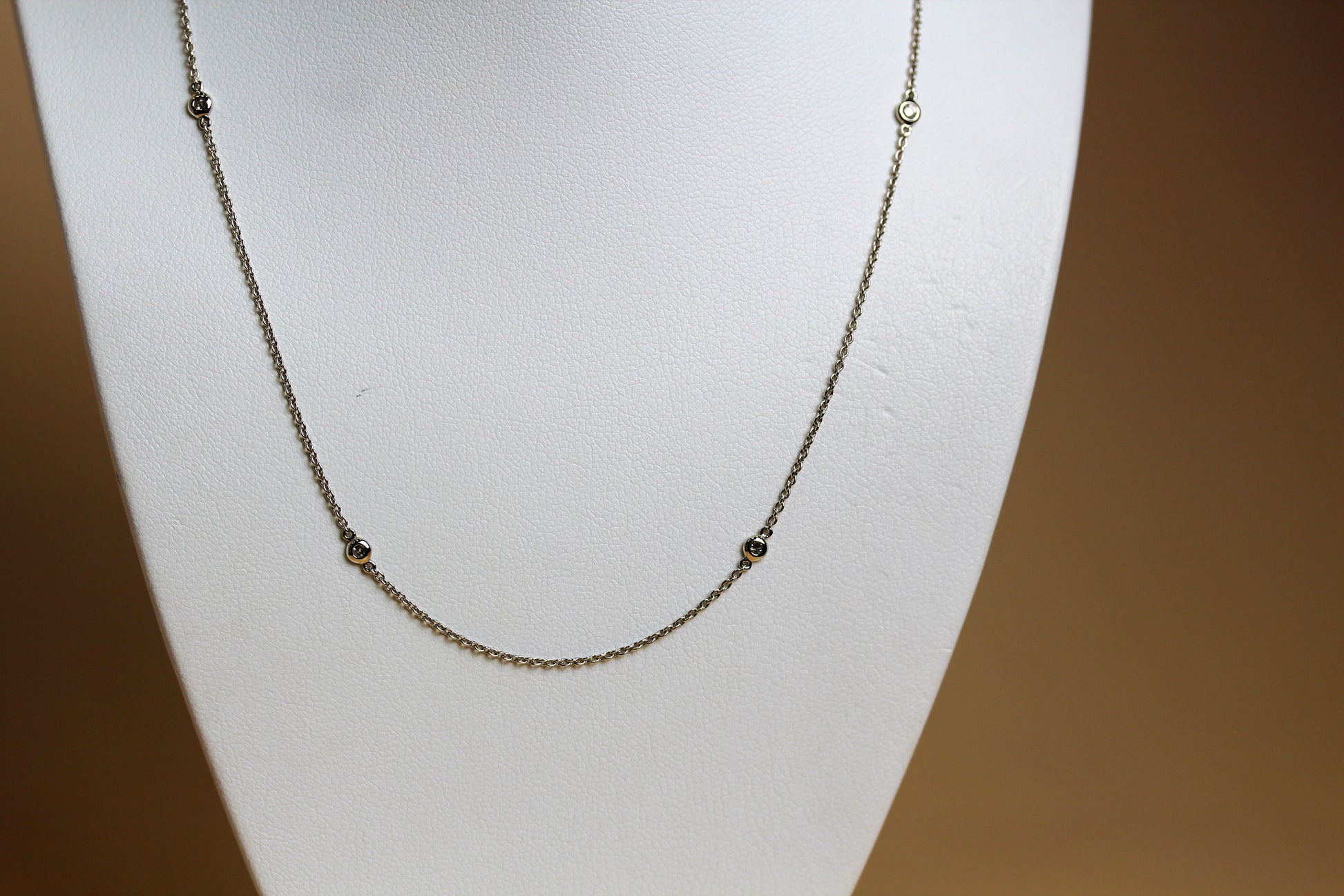 Close-up of natural round brilliant diamond in 18ct white gold bezel station setting — Jon Crosbie Jeweller