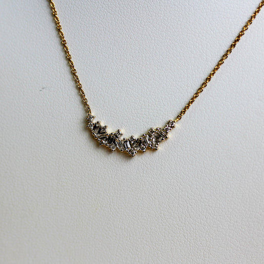 Close-up of mixed-cut diamond curved bar in 9ct gold showing baguette and round brilliant claw settings — Jon Crosbie Jeweller