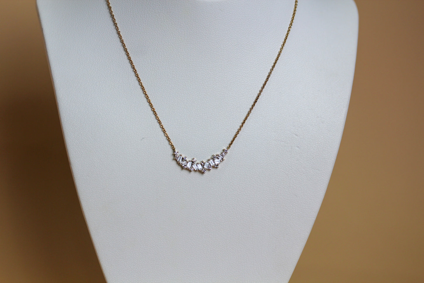 9ct yellow gold curved bar necklace with scattered baguette and round brilliant diamonds, 0.25ct total diamond weight, claw set