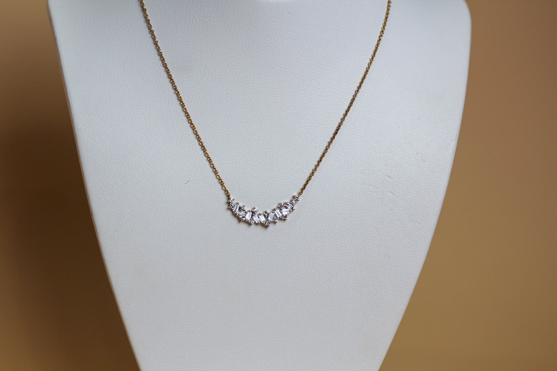 9ct yellow gold curved bar necklace with scattered baguette and round brilliant diamonds, 0.25ct total diamond weight, claw set